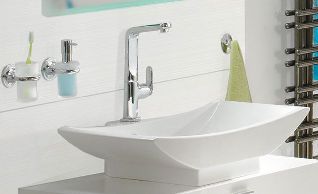 Dunkle Strukturfliesen mit dreidimensionaler Oberfläche, daneben ein Waschtisch mit gelbem Handtuch und Waschbecken.